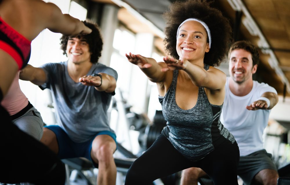 Beautiful fit people friends exercising together in gym